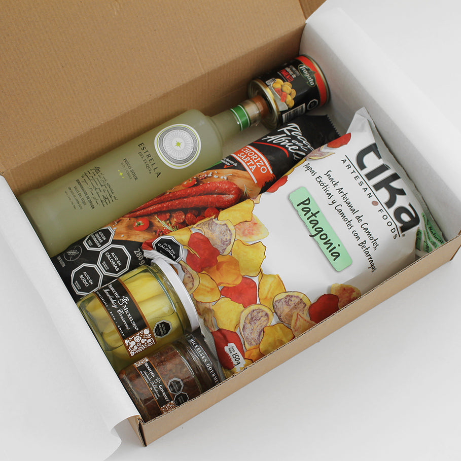 Caja gourmet con Pisco Sour Estrella del Elqui, chorizo artesanal, tapenade, chips, aceitunas y papayas en conserva. Un regalo corporativo lleno de sabor y distinción.