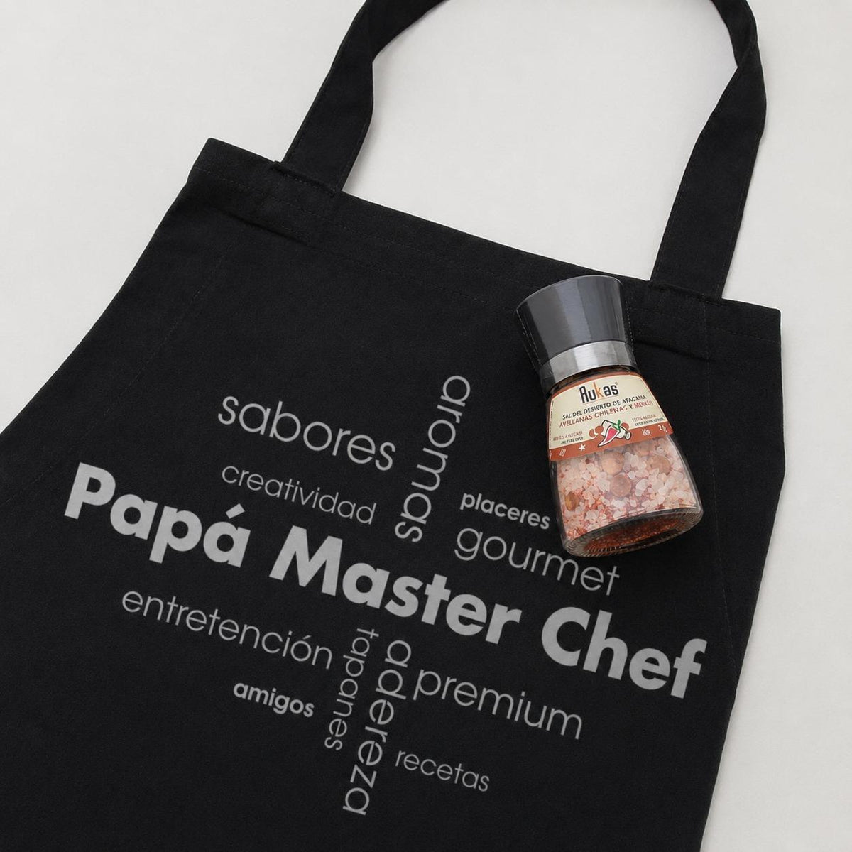 Pechera con logo impreso y molinillo de sal del desierto de Atacama con especias Aukas. En bolsa con tarjeta personalizada.
