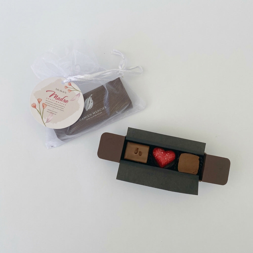 Sorprende a mamá en su día con la elegancia de 3 bombones artesanales Damien Mercier. Presentación exclusiva en bolsa de organza blanca y tarjeta especial. ¡El detalle gourmet perfecto para su día! Cotiza con nosotros.