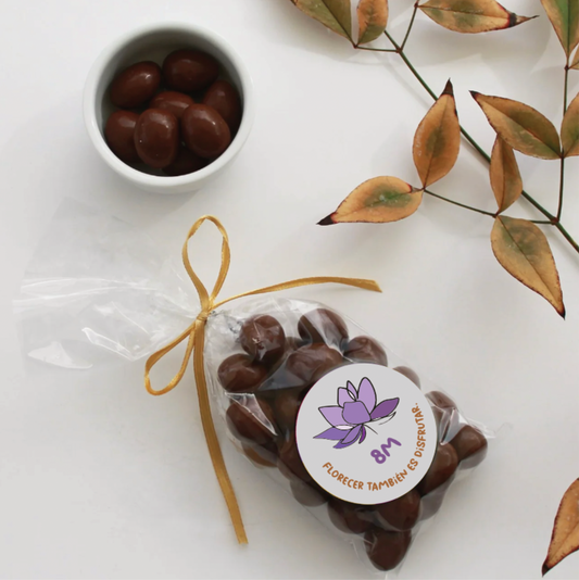 Detalle de dulzura 8M: Almendras con chocolate La Romería en bolsa de celofán. Incluye mensaje personalizado y logo. Calidad premium para regalos empresariales por volumen. ¡Sorprende con Aporta Imagen!
