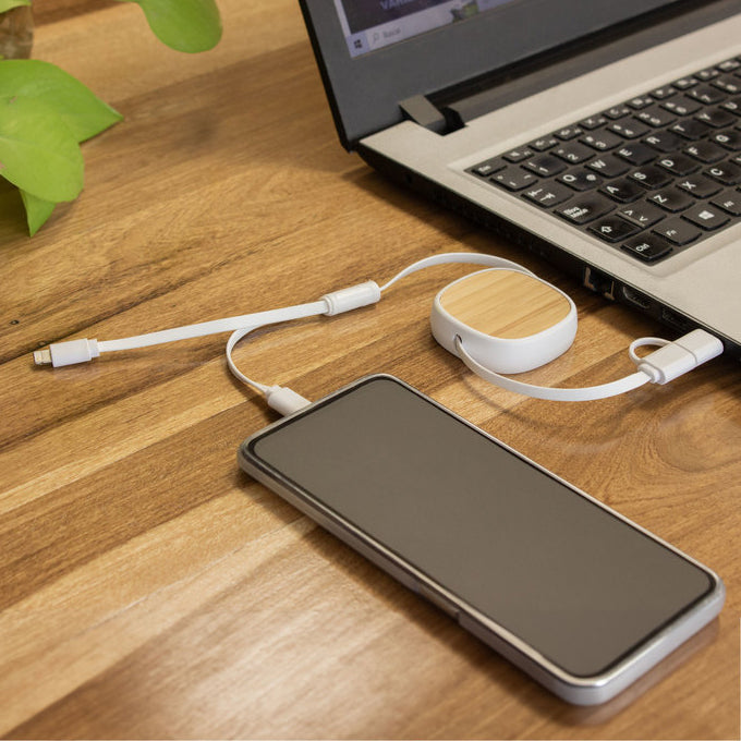 Cable de carga retráctil de hasta 85 cm con detalle de bambú y conectores Lightning, USB-C y USB. Personalizable con logo grabado. Ideal para regalos corporativos.