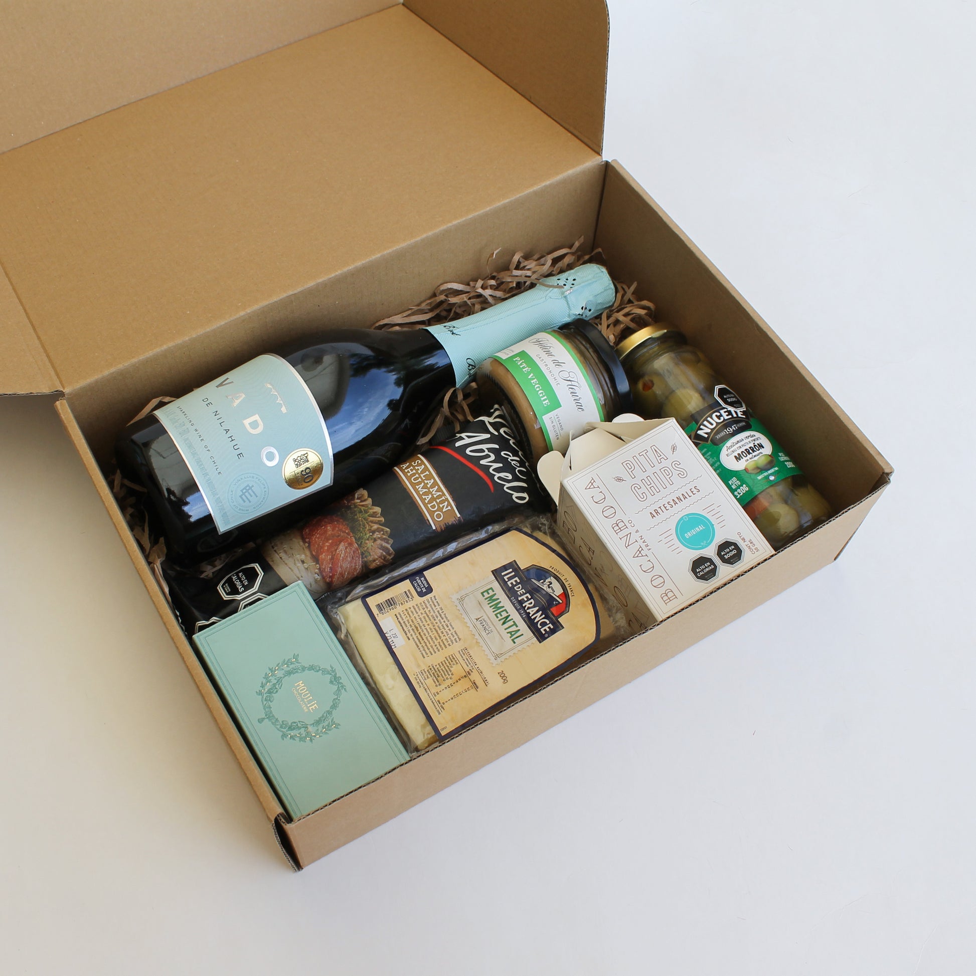 Caja con espumante Vado 750cc, queso emmental, paté, salamín, aceitunas y florentinas Moulie. En caja kraft con tarjeta personalizada. Regalo corporativo.