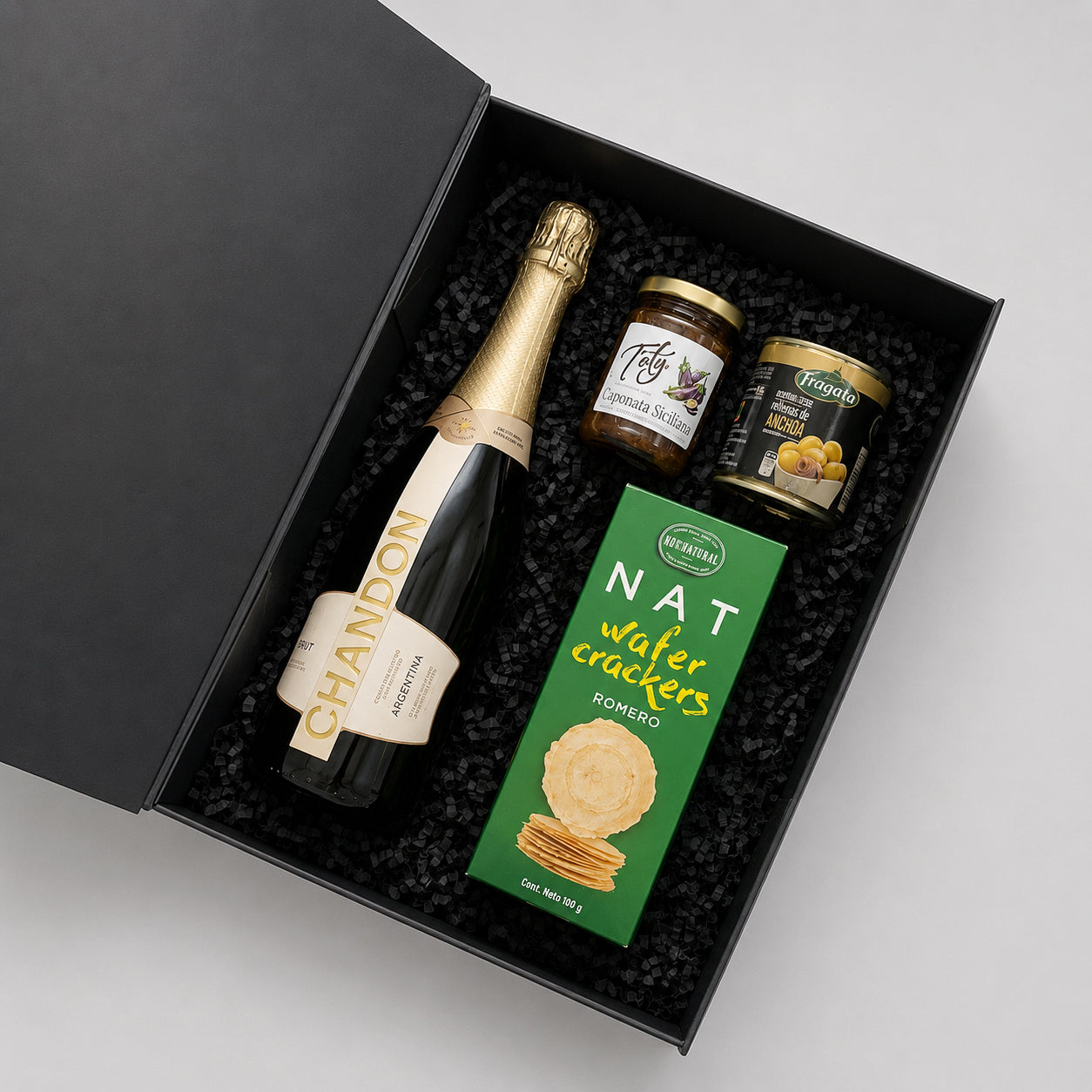 Caja gourmet con espumante Chandon Brut, producto gourmet Toty y aceitunas rellenas Fragata. Un regalo corporativo elegante para celebrar y compartir momentos especiales.