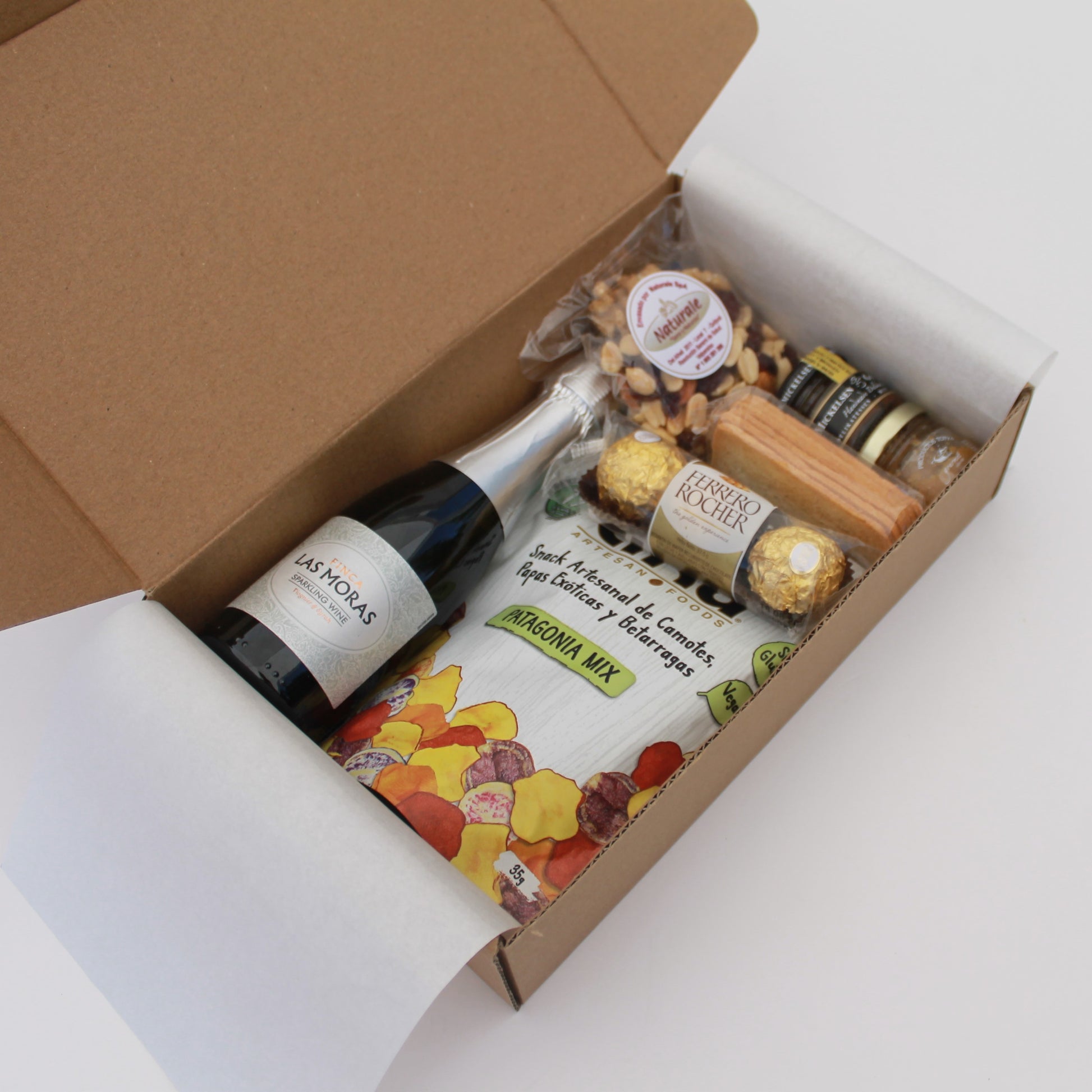 Caja gourmet con espumante, tapenade, pasta gourmet, frutos secos, snacks y chocolates. Un regalo corporativo que aporta imagen y genera experiencias memorables.