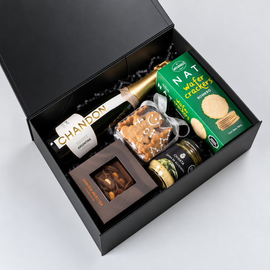 Regalo corporativo de Navidad con espumante Chandon, chocolates Damien Mercier y selección gourmet en elegante caja negra. Pedido mínimo: 20 unidades.