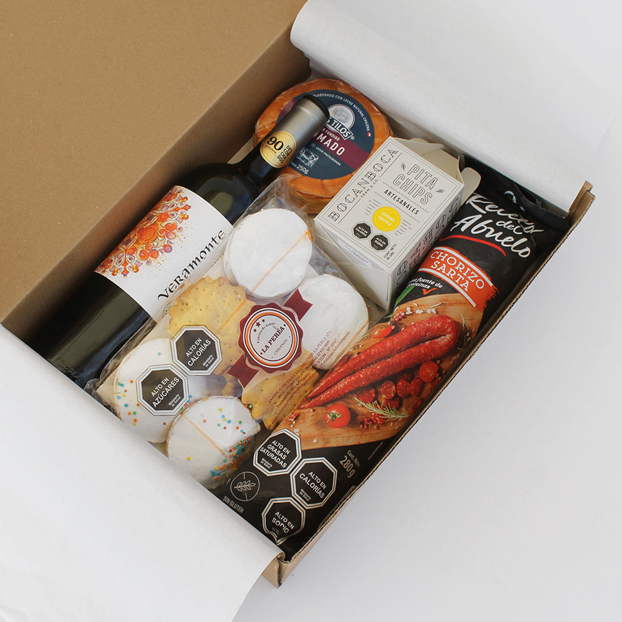 Caja gourmet con vino orgánico Veramonte, queso ahumado, chorizo artesanal, pita chips y dulces chilenos. Un regalo corporativo que celebra los sabores auténticos de Chile.