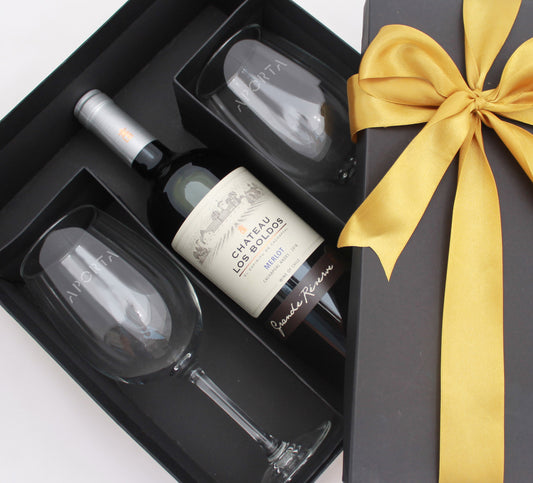 2 copas de cata con logo empavonado y vino Chateau los Boldos Gran Reserva. En caja forrada con cinta y tarjeta personalizada.
