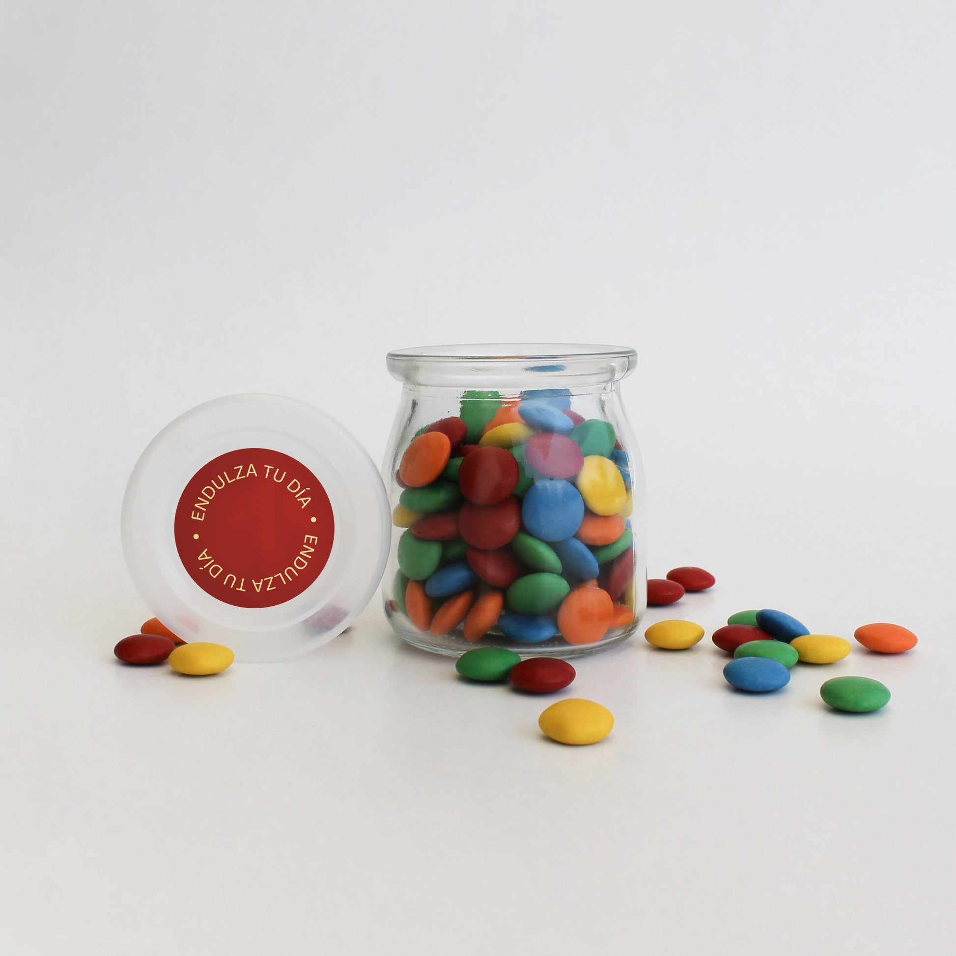 Frasco de vidrio reutilizable con chocolates Chubi y sticker personalizado. Detalle corporativo dulce y memorable.