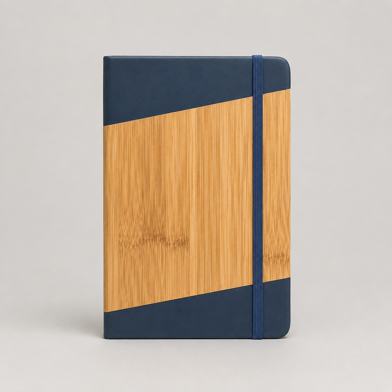 Libreta A5 con tapa dura de poliuretano acabado símil bambú, 80 hojas rayadas, cinta señaladora y banda elástica. Un regalo corporativo elegante y personalizable con logo.