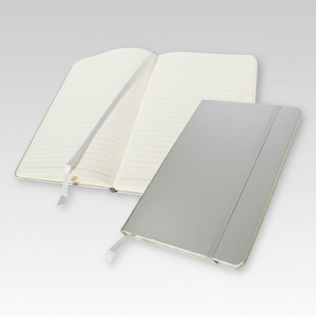 Libreta A6 modelo Colorskine con cubierta forrada, 80 hojas lineadas amarillas, banda elástica y cinta separadora al tono. Disponible en varios colores con logo impreso.
