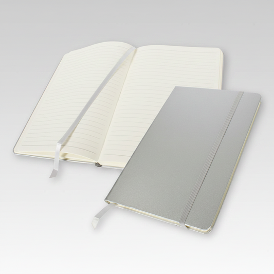 Libreta A6 modelo Colorskine con cubierta forrada, 80 hojas lineadas amarillas, banda elástica y cinta separadora al tono. Disponible en varios colores con logo impreso.