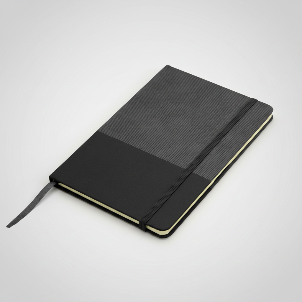 Libreta con tapa de cartón recubierta en poliuretano bicolor, 80 hojas rayadas, cierre elástico y cinta señaladora. Personalizable con logo corporativo.