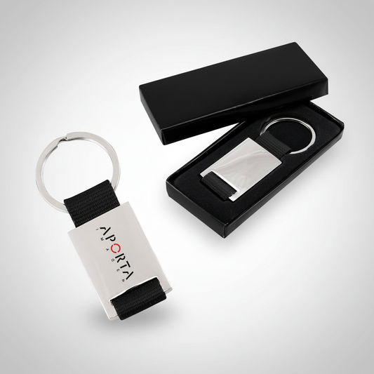 Llavero metálico con strap de poliéster en variados colores. Práctico, resistente y personalizable con logo corporativo para campañas promocionales y eventos.