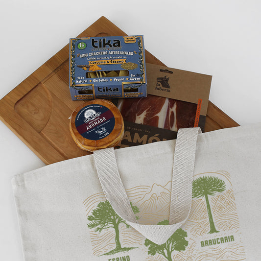 Kit Parrillero Premium: Tabla de lenga (34x48cm), selección gourmet y bolso de algodón natural con diseño nativo. La solución perfecta para regalos corporativos en el Día del Trabajador. ¡Cotiza!