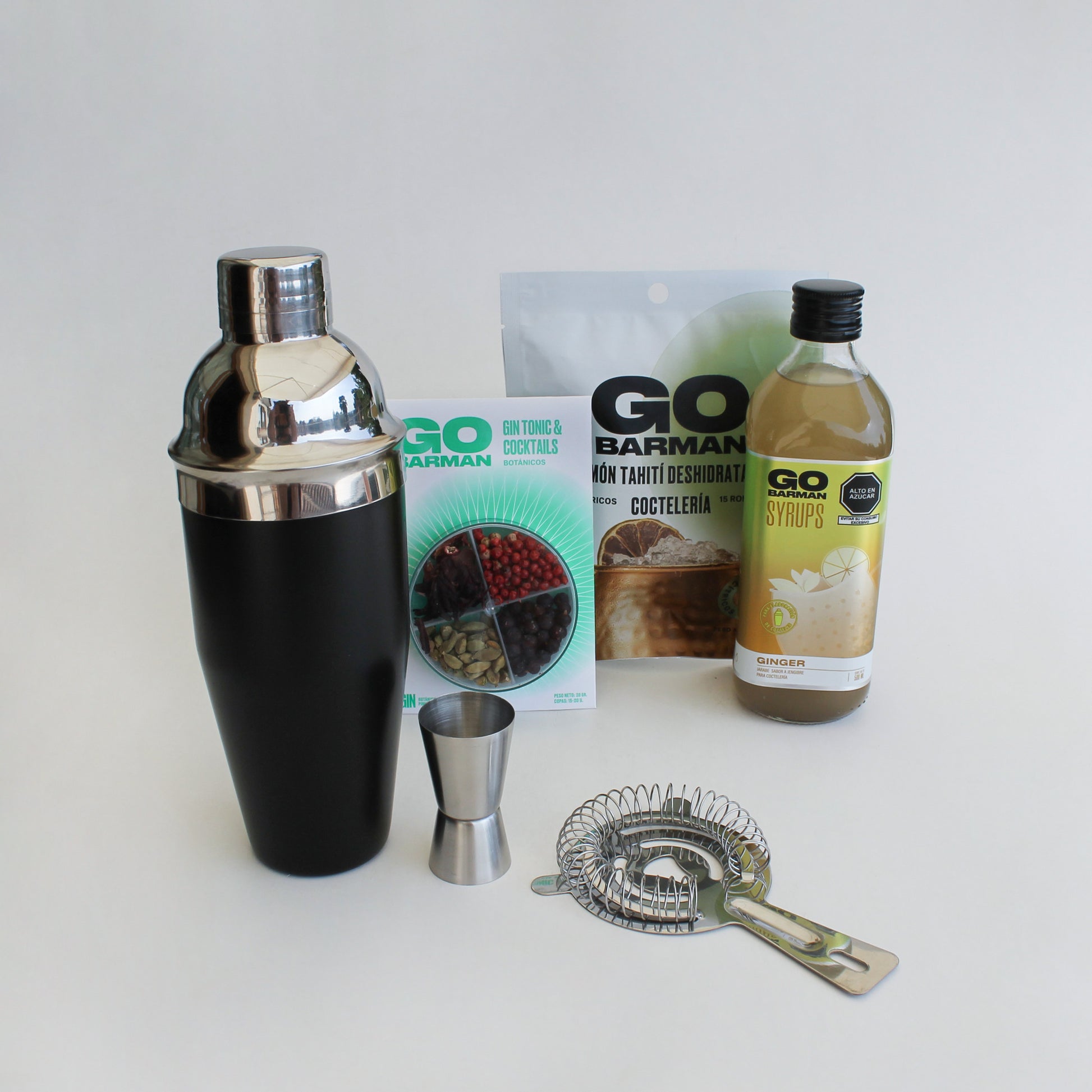 Regalo corporativo que contiene una coctelera 600ml, vaso mezclador, jigger, colador, botánicos, syrup y deshidratados Go Barman. Logo grabado opcional.