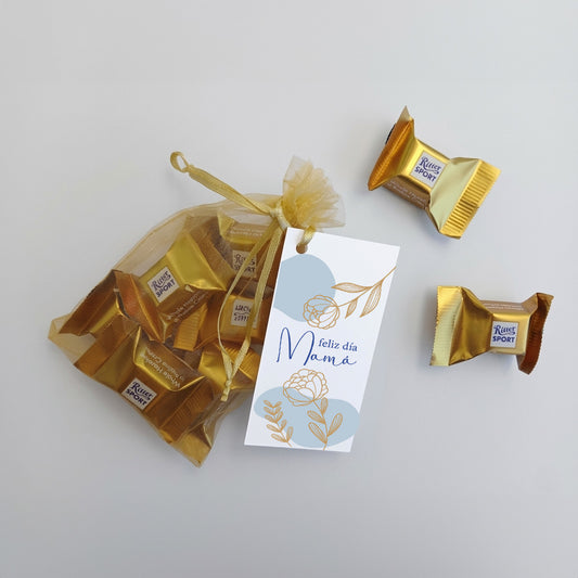 Sorprende a tu equipo con un detalle exclusivo para el Día de la Madre: 8 Ritter Sport Mini Cubes en bolsa de organza dorada. Incluye tarjeta personalizada. Pedido mín. 100 unids. Cotiza con nosotros