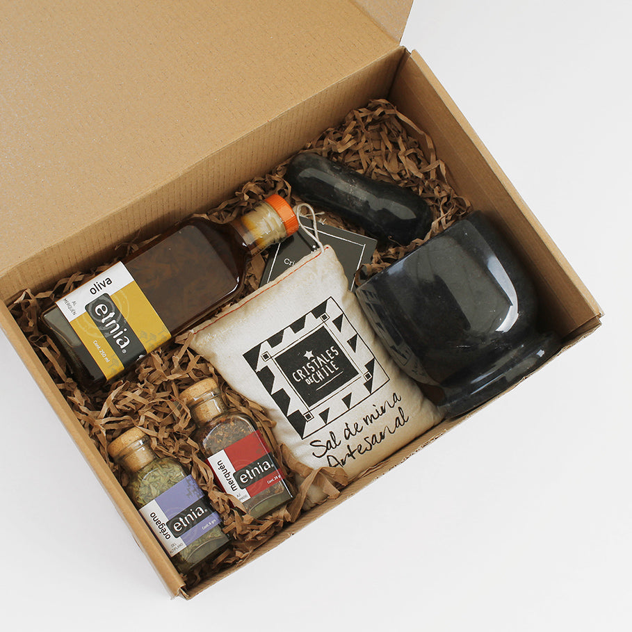 Set gourmet con mortero de piedra, sal Cristales de Chile, aceite de oliva al merkén y especias. Presentado en caja kraft con tarjeta personalizada.