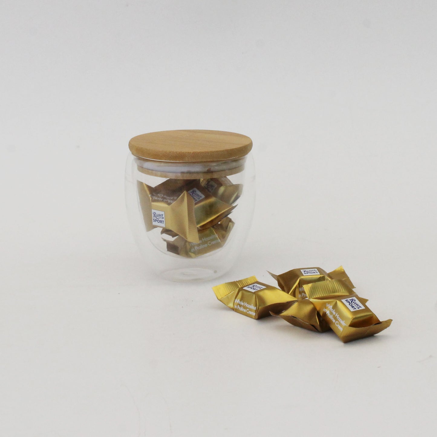Taza doble vidrio con tapa de bambú grabada a láser y chocolates Ritter Gold. Regalo corporativo premium para el Día del Trabajador. Mín. 100 unidades. ¡Cotiza!