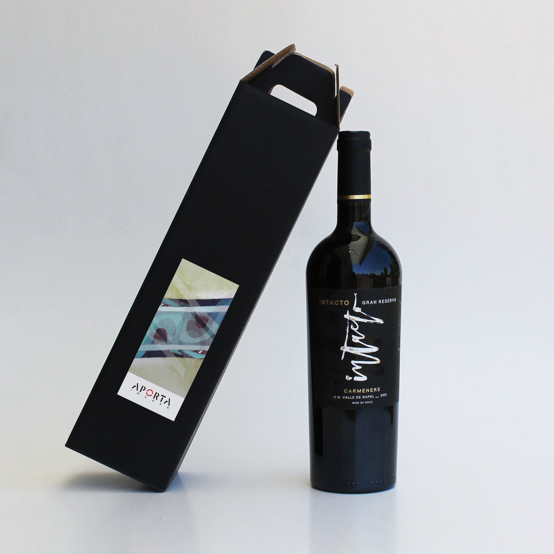 El regalo ideal para unir al equipo. Vino Intacto Gran Reserva 700ml presentado en elegante caja de cartón microcorrugado con asas. Disponible en negro o kraft con sticker personalizado. ¡Calidad y distinción para celebrar el Día del Trabajador!