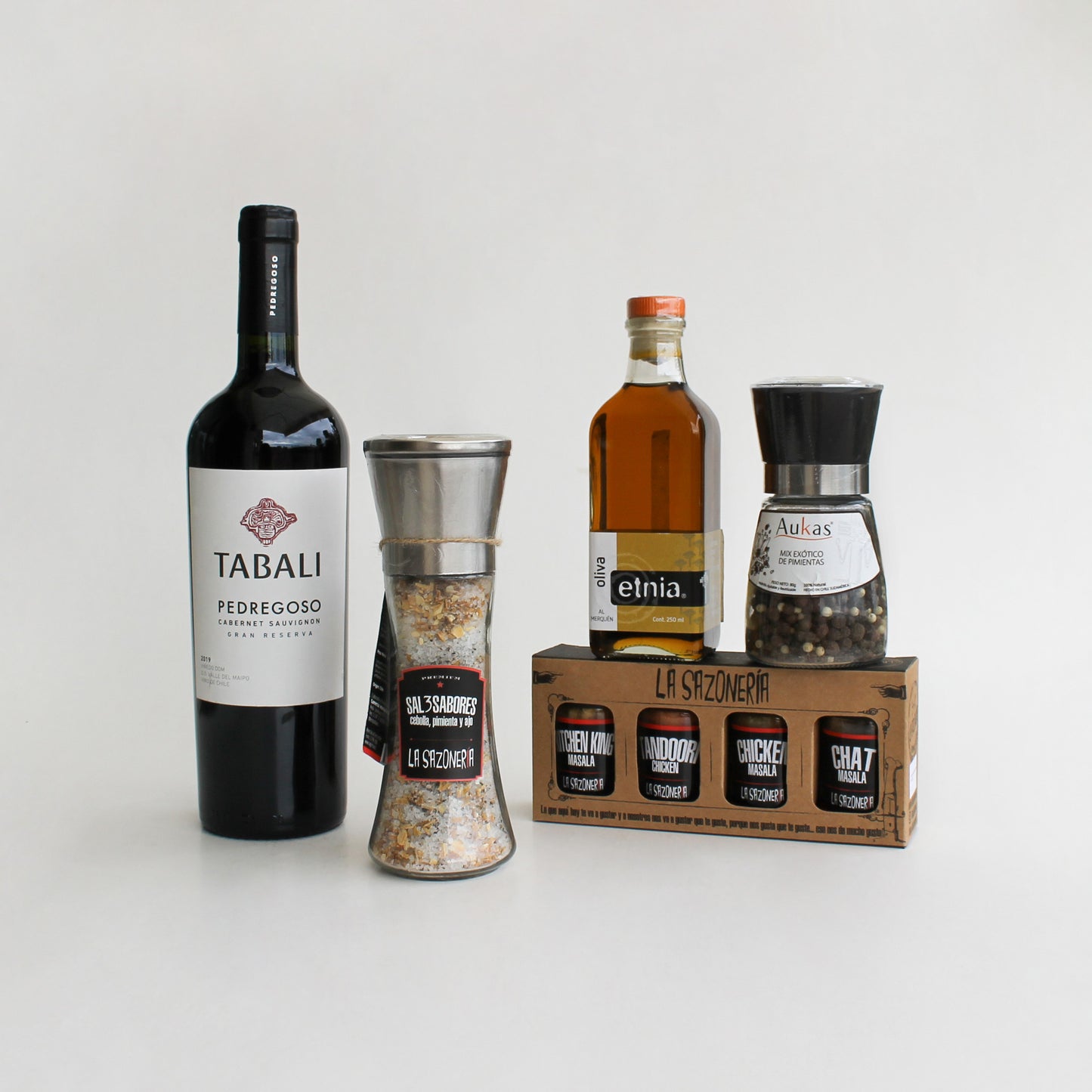 Vino Tabalí, aceite al merquén, molinillo de sal, pimientas y especias La Sazonería en caja kraft con logo. Regalo gourmet para el Día del Padre.